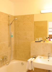 a bathroom with a shower and a tub and a sink at Hotel Blauer Bock in Munich