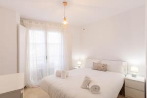 biała sypialnia z białym łóżkiem i ręcznikami w obiekcie El Salvador City Center Suite by Valcambre w Sewilli