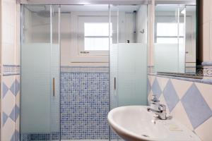 łazienka z umywalką i przeszkloną kabiną prysznicową w obiekcie El Salvador City Center Suite by Valcambre w Sewilli +11 zdjęć