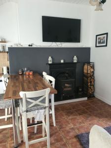 a dining room with a table and a fireplace at The Speak Easy Cottage Multyfarnham 0876682090 in Multyfarnham
