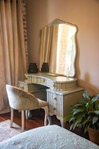 a dressing table with a mirror and a chair at La Casa Nostra Villa Rose Garden Amore in Hillcrest