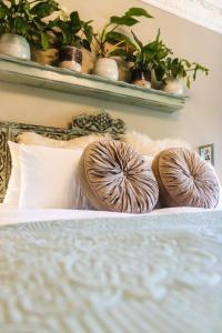 a bed with two pillows on top of it at La Casa Nostra Villa Rose Garden Amore in Hillcrest