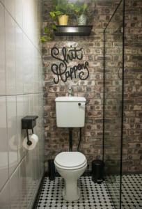 a bathroom with a toilet and a brick wall at La Casa Nostra Villa Rose Garden Amore in Hillcrest +34 photos