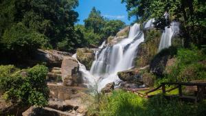 a waterfall in the middle of a forest at Smile Place (สมายเพลส) in Chom Thong
