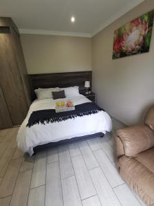 a bedroom with a large bed and a couch at Up21 Guest House in Boksburg