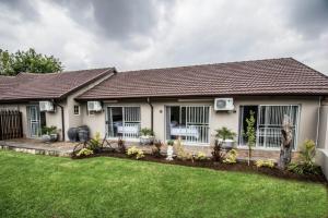 a house with a green lawn in front of it at Up21 Guest House in Boksburg