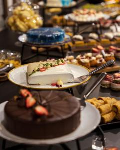 a cake on a plate on a table with other desserts at Gorski Hotel & Spa in Kopaonik