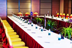 une longue table dans une salle de conférence avec des chaises jaunes dans l'établissement Muong Thanh Luxury Quang Ninh Hotel, à Hạ Long