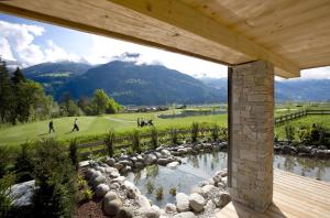 a view of a golf course from the porch of a house at ZillerLodge in Uderns