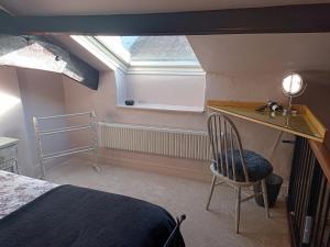a bedroom with a bed and a desk and a chair at Longbridge Cottage in Shepton Mallet