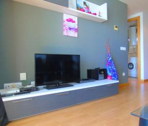 ein Wohnzimmer mit einem Flachbild-TV auf einem Entertainment-Center in der Unterkunft Bel Appartement avec Attico proche Commerces in Roses
