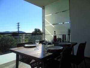 einen Esstisch mit Blick auf ein großes Fenster in der Unterkunft Bel Appartement avec Attico proche Commerces in Roses