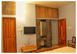 a room with a bed and a tv and wooden cabinets at High Island Homestay in Cochin