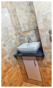 Łazienka z umywalką i ścianą wyłożoną kafelkami w obiekcie High Island Homestay w mieście Koczin