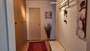 einen Flur mit einer Tür und ein Zimmer mit einem roten Teppich in der Unterkunft Valnaira (282 Dä) in Valbella