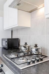 een keukenfornuis met potten en pannen erop bij 2 Bedroom serviced apartment in Londen