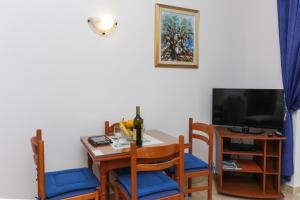 a dining room with a table with chairs and a television at K-apartments in Dubrovnik