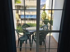 a table and chairs on a balcony with a window at El SOL del SUR in La Herradura