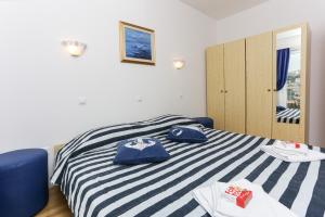 1 dormitorio con cama de rayas azul y blanco en K-apartments, en Dubrovnik 21 fotos más