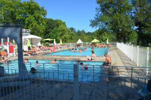 圣吉隆Camping Parc d'Audinac les Bains 3 étoiles - Piscine chauffée - Vue montagne的一群人在游泳池里游泳
