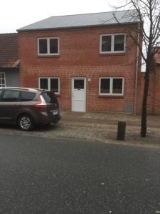 un'auto parcheggiata di fronte a una casa di mattoni di Bramming city privat gæstehus a Bramming