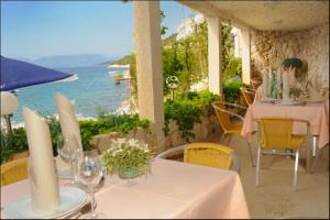 un restaurante con mesa y vistas al océano en Hotel Porat, en Neum