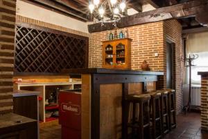 a bar with stools in a room with a brick wall at Casa Rural Paco in Muñogalindo