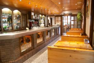 a bar in a restaurant with wooden floors and benches at Sol i Neu in Ribera de Cardós