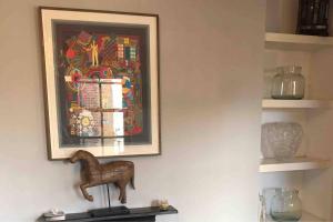 a painting on a wall with a figurine on a shelf at Remarkable Apartment near London Tower Bridge in London