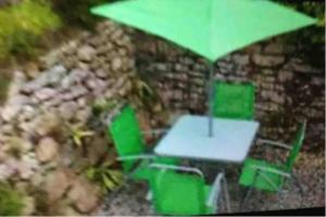 a table and chairs with a green umbrella at Remarkable Apartment near London Tower Bridge in London