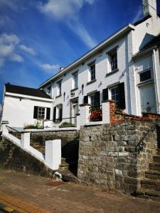 ein weißes Haus mit einer Steinmauer davor in der Unterkunft Villers la villA in Villers-la-Ville