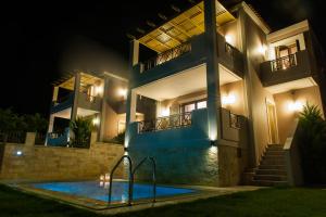 a house with a swimming pool at night at Villa Harmony-Crete Residences in Adelianos Kampos