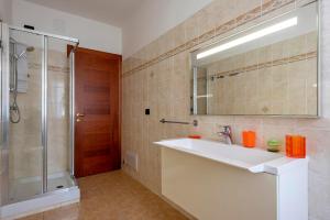 łazienka z umywalką, prysznicem i lustrem w obiekcie Egeo apartment w mieście Alghero +12 zdjęć