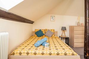 1 dormitorio con 1 cama con almohadas azules en Utopia - GOLDEN TREE - WIFI - 20min St-Croix & Center Parcs, en Sarrebourg