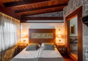 勞羅塔瓦的住宿－CASA RURAL EL LAGAR TENERIFE，一间卧室配有一张大床,两边都配有两盏灯