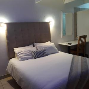 een slaapkamer met een groot bed met 2 kussens bij Belavista, quaint and cozy cottage in Sunwich Port in Port Shepstone