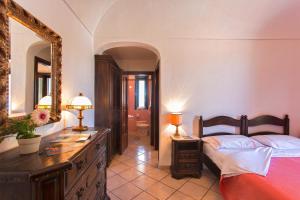 1 dormitorio con cama, tocador y espejo en Hotel San Valentino Terme, en Isquia
