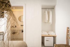 a bedroom with white walls and a bed and a closet at Meloussa Boutique Hotel in Ciutadella