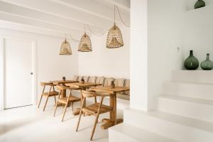 a dining room with a wooden table and chairs at Meloussa Boutique Hotel in Ciutadella
