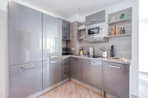 a kitchen with stainless steel appliances and wooden floors at limehome Köln Friesenplatz - Digital Access in Cologne