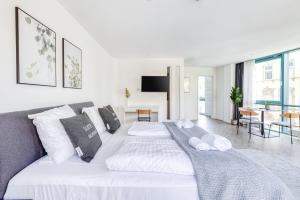 a white bedroom with a large white bed with pillows at Limehome Köln Friesenplatz - Digital Access in Cologne +50 photos