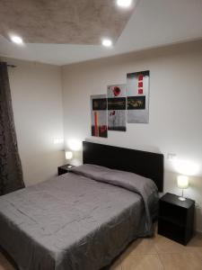 1 dormitorio con 1 cama y 2 mesitas de noche en Anthea Dell' Etna en Santa Venerina