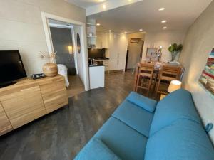 ein Wohnzimmer mit einem blauen Sofa und einer Küche in der Unterkunft Immodelpas Grizzly in Pas de la Casa
