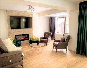 uma sala de estar com um sofá e cadeiras e uma lareira em Holiday Home in Sinaia em Sinaia
