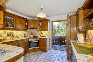 una cocina con armarios de madera y una gran ventana en Haus Waldeck en Reit im Winkl