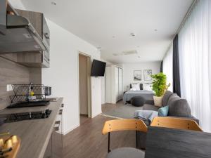 een woonkamer met een bank en een bed bij limehome Köln Friesenplatz - Digital Access in Keulen