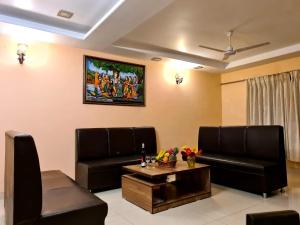 a living room with two leather chairs and a table at Fogg Villa - Valley View / Swimming pool / AC in Mahabaleshwar