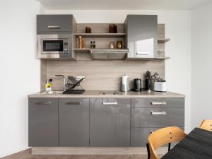a kitchen with stainless steel cabinets and a sink at Limehome Köln Friesenplatz - Digital Access in Cologne