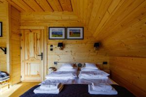 1 dormitorio con 2 camas en una cabaña de madera en Góralski domek z bali SAŁAS, en Ząb
