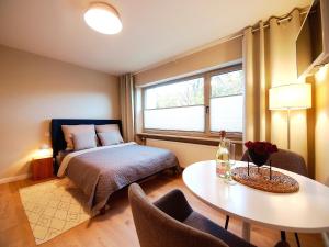 a bedroom with a bed and a table and a window at Apartmenthaus Schön in Bad Neustadt an der Saale
